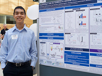 Jordan standing next to his research poster